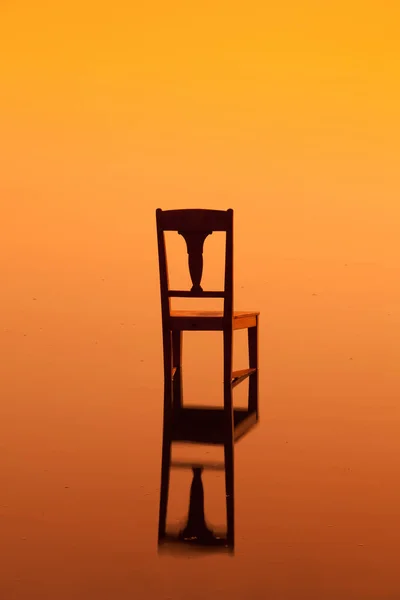 Houten stoel op het oppervlak van een vijver — Stockfoto