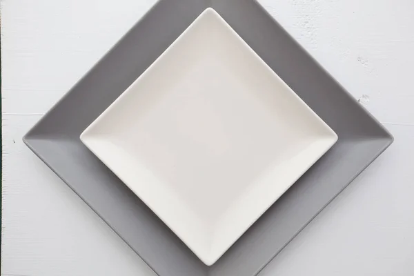 Lege witte keramische schotel op over witte houten tafel — Stockfoto