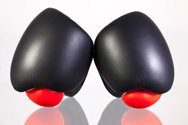 Red and black boxing gloves on a glass table — Stock Photo, Image