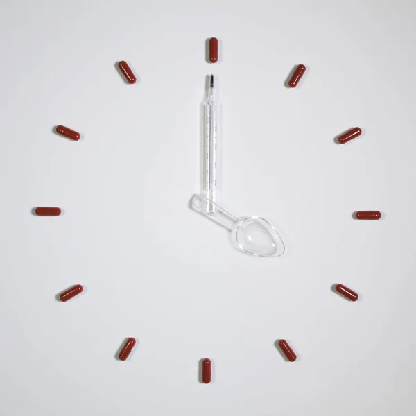 12 Pillen, medizinisches Thermometer und Plastiklöffel — Stockfoto