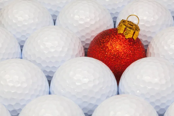Červená vánoční dekorace mezi golfové míčky — Stock fotografie