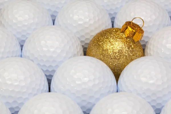 Decoración navideña de oro entre las bolas de golf —  Fotos de Stock