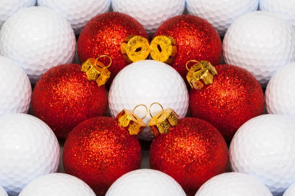 Red Christmas decoration between the golf balls — Stock Photo, Image