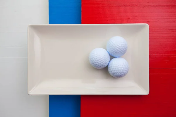 Белая керамическая тарелка с мячами для гольфа — стоковое фото