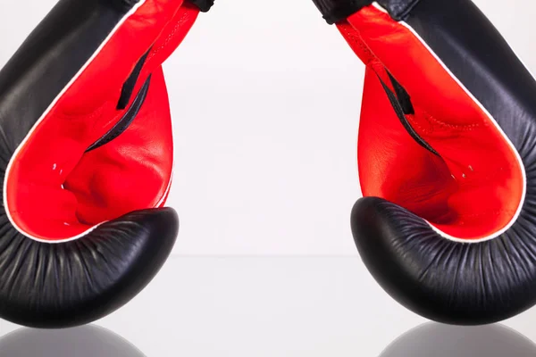 Red and black boxing gloves on a glass table — Stock Photo, Image