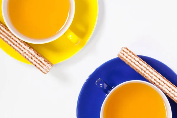Tazze di tè perfette sul tavolo di legno con cialde dolci — Foto Stock