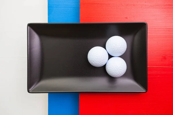 Black ceramic dish with golf balls — Stock Photo, Image