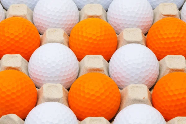 White and orange golf balls in the box — Stock Photo, Image