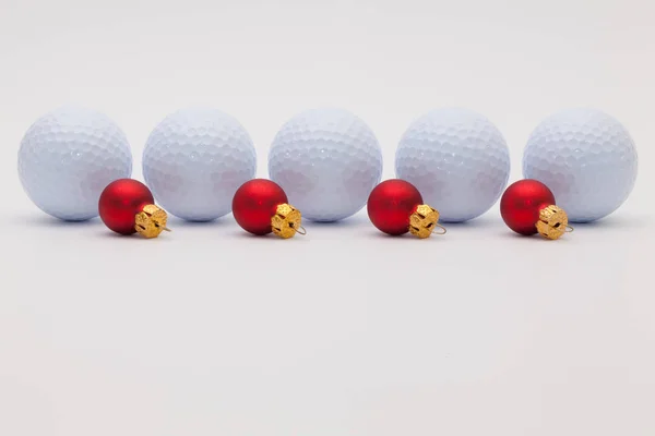 Гольф шары и красные рождественские украшения — стоковое фото