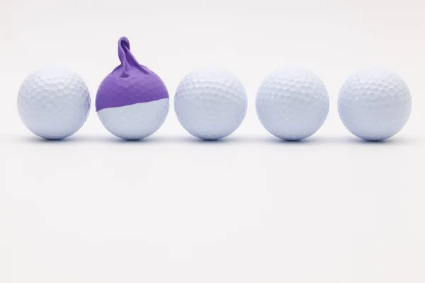 Bolas de golfe branco com boné engraçado no fundo branco . — Fotografia de Stock