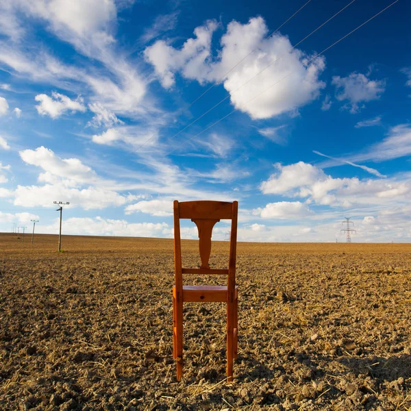Old wooden chair on the empty field — Stock Photo, Image