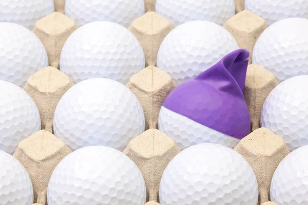 Bolas de golf blancas en la caja para huevos. Pelota de golf con gorra divertida . —  Fotos de Stock