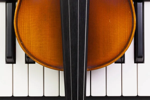 Стара скрипка лежить на піаніно — стокове фото