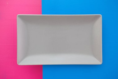 Boş gri seramik tabak üzerinde mavi ve pembe arka plan, rectan üzerinde