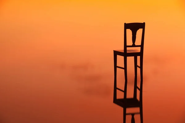 Houten stoel op het oppervlak van een vijver — Stockfoto