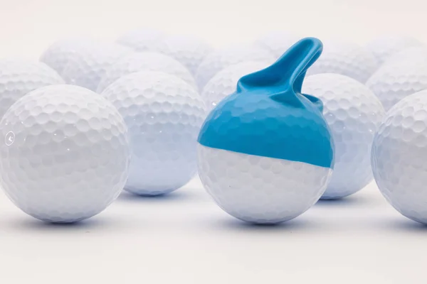 Bolas de golfe branco com boné engraçado no fundo branco . — Fotografia de Stock