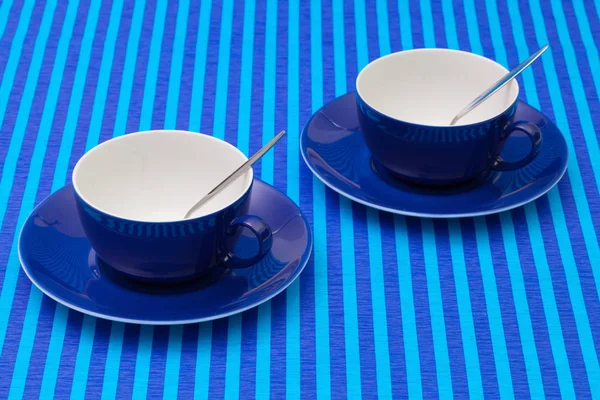 Arrangement de symétrie tasses de thé vides sur nappe rayée bleue — Photo