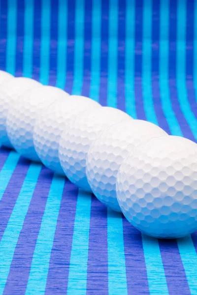 Μπάλες του γκολφ λευκό μπλε ριγέ τραπέζι. — Φωτογραφία Αρχείου