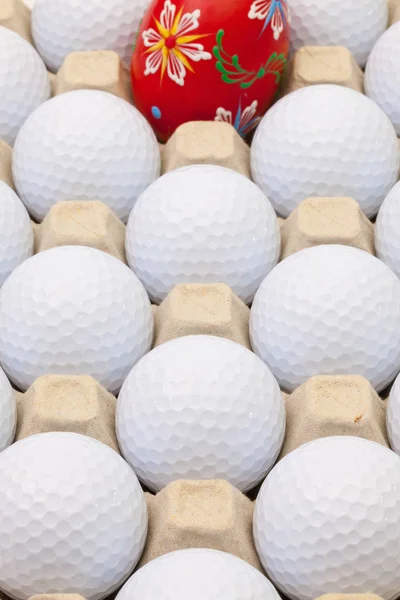 Мячи для гольфа в коробке для яиц и пасхальных украшений — стоковое фото