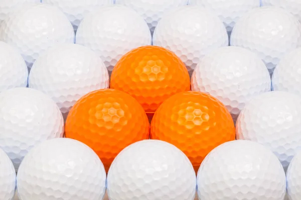 Bílé a oranžové golfové míčky v poli — Stock fotografie