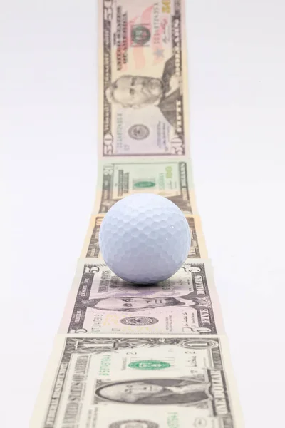 Tira de diferentes notas de dólar americano e bola de golfe branco — Fotografia de Stock