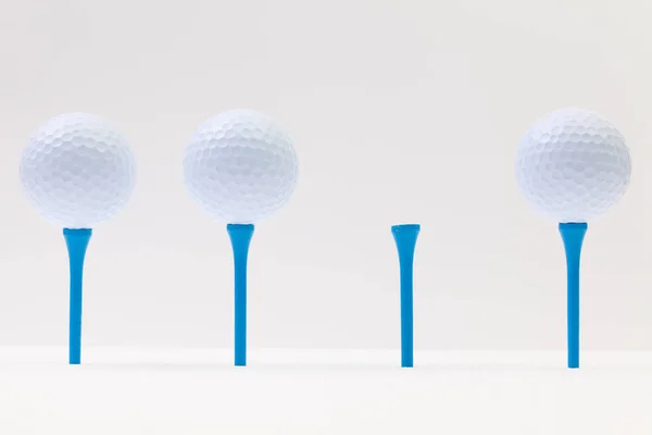 Beyaz golf topları ve beyaz masada mavi tees — Stok fotoğraf