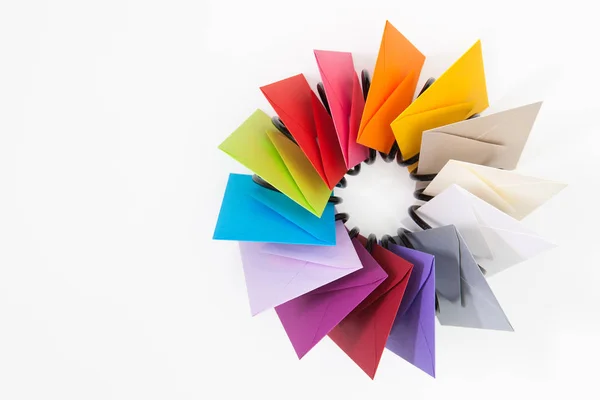 Pervane beyaz masa üzerinde renkli zarf — Stok fotoğraf