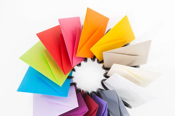 Śmigło kolorowych kopert na biały biurko — Zdjęcie stockowe