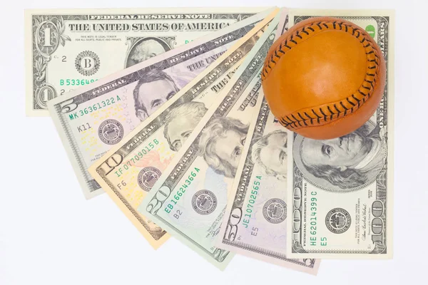 Pelota de béisbol de cuero y billetes en dólares . — Foto de Stock