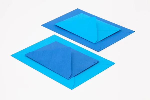 Quebra-cabeça de grandes e pequenos envelopes azuis na aba branca — Fotografia de Stock