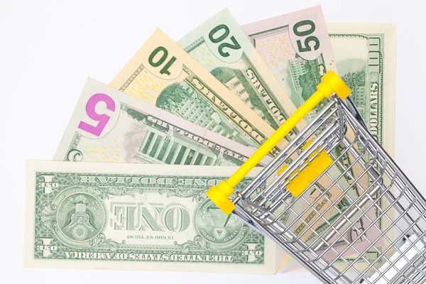 Verschiedene Dollarnoten und leerer Einkaufswagen. — Stockfoto