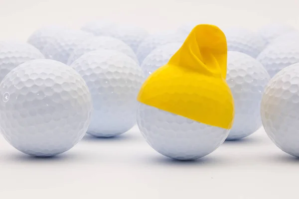 Bílé golfové míčky s srandovní čepici na bílém pozadí. — Stock fotografie