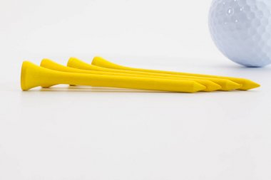 Ahşap golf tee ve golf topu beyaz masada