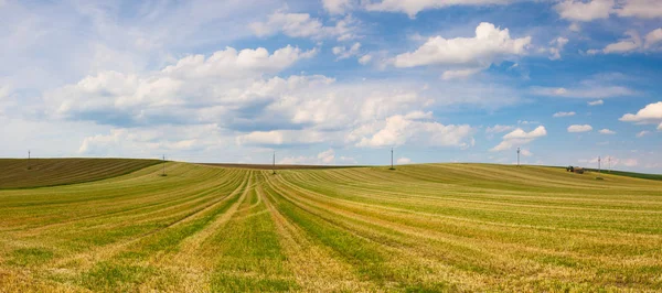 Traktor auf dem abgeernteten, leeren Feld auf den Hügeln — Stockfoto