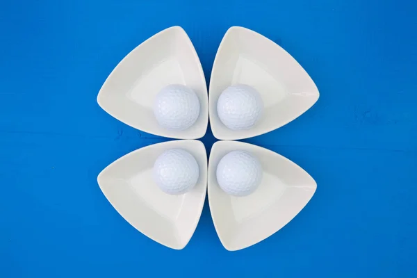 White golf balls on the triangular ceramic bowls — Stock Photo, Image