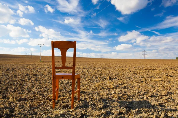 Alter Holzstuhl auf dem leeren Feld — Stockfoto