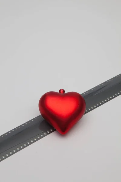 Das rote Herz und die ungerollten belichteten 35mm-Filmstreifen — Stockfoto