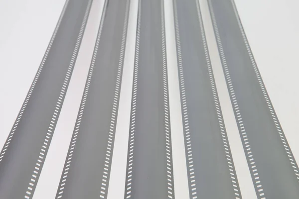 Le strisce di pellicola 35mm esposte srotolate su uno sfondo bianco — Foto Stock