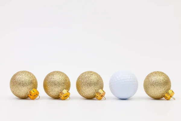 Золотое рождественское украшение и белый мяч для гольфа — стоковое фото