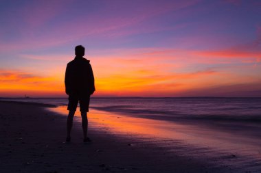 Cape Cod, Massachusetts, ABD - Temmuz 13,2016: dramatik gün batımında boş sahilde yalnız adam. Cape Cod, ABD