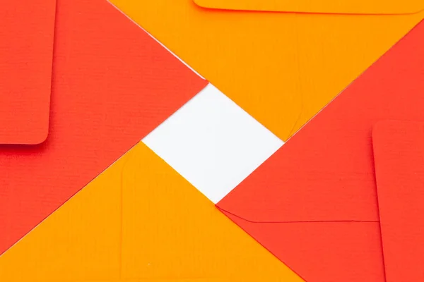 Rode en oranje enveloppen op de witte tafel — Stockfoto