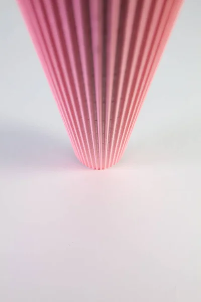 Falistej różowy papier rolka na biały biurko. — Zdjęcie stockowe
