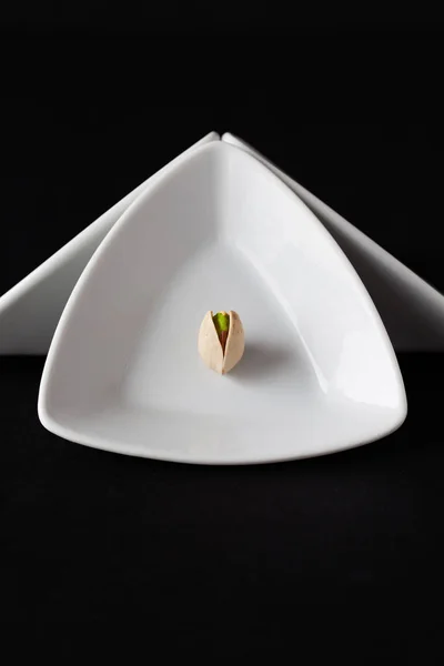 Witte driehoekige keramische kommen met pistache noten. — Stockfoto