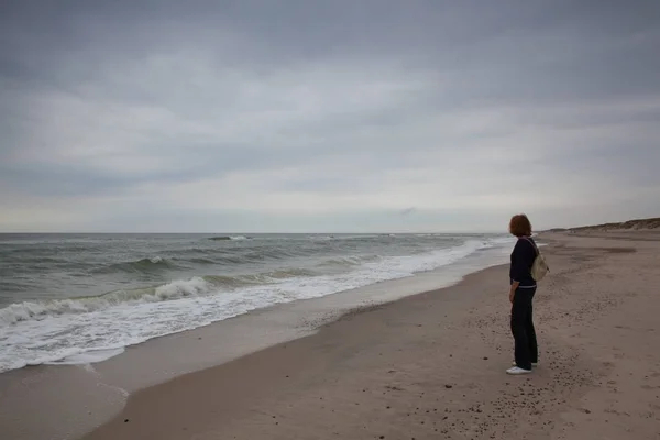 Eenzame vrouw op het strand. Jutland, Denemarken. — Stockfoto