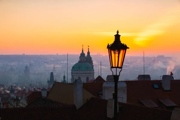 Nascer do sol atrás de uma velha lâmpada de rua sobre Lesser Town, Praga, Czec — Fotografia de Stock