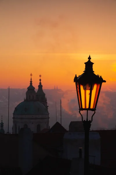 Sunrise behind an old street lamp over Lesser Town, Prague, Czec — Stock Photo, Image