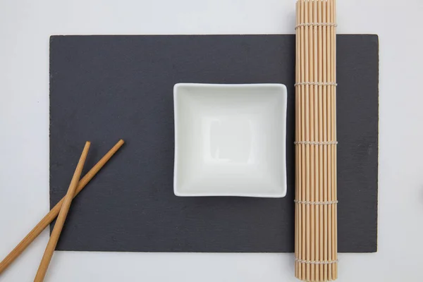 Rechthoekige leisteenplaat met eetstokjes, keramische plaat, bamboe — Stockfoto