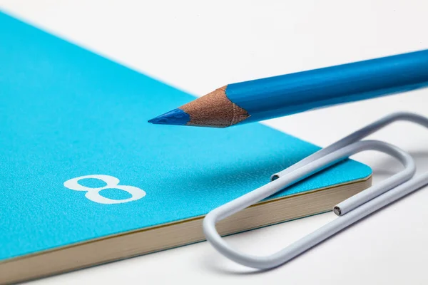 8月の主催者 白いテーブルの上の青い鉛筆と白い紙クリップ — ストック写真