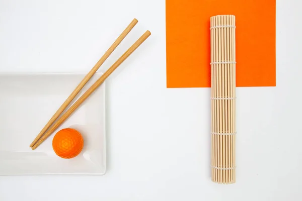 竹箸とゴルフボール付きの白い空の寿司プレートのトップビュー ゴルフデザイン — ストック写真