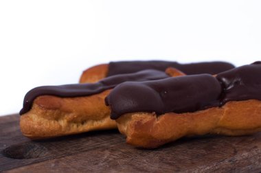 Beyaz izole tatlı üç çikolata eklerleri. Geleneksel Fransız pastaları choux hamur pişmiş bir krem ile dolu